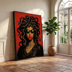 May include: Framed art print featuring a stylized illustration of Medusa with sunglasses and a bubblegum bubble. The artwork has a red background and a black frame. The Medusa figure has snakes for hair and is wearing sunglasses.