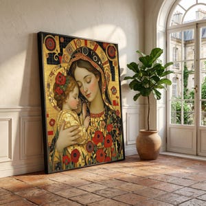 Puede incluir: Impresión artística enmarcada que representa a una madre y un niño, en tonos dorados, negros y rojos. La obra de arte presenta patrones intrincados y elementos florales, creando una estética decorativa y espiritual. La impresión se exhibe en una habitación con una planta y una ventana.