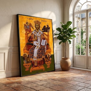 May include: Framed religious icon featuring a seated figure in ornate robes and a crown, holding a book. The artwork has a gold background with angels and text. The frame is black, and the overall style is Byzantine.