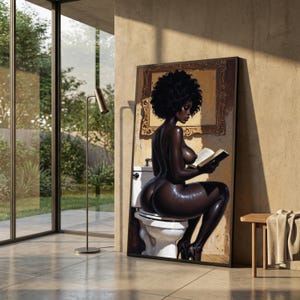 Puede incluir: Una impresión de arte mural vertical que muestra a una persona de piel oscura con un gran peinado afro sentada en un inodoro blanco mientras lee un libro abierto. La figura se encuentra en un baño con un marco de fotos dorado y ornamentado.