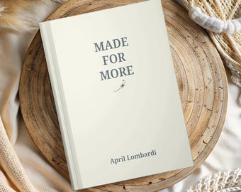 May include: A cream-colored book with the words "MADE FOR MORE" printed in dark gray. The author's name, April Lombardi, is printed below the title. The book is on a wooden tray with a neutral background.
