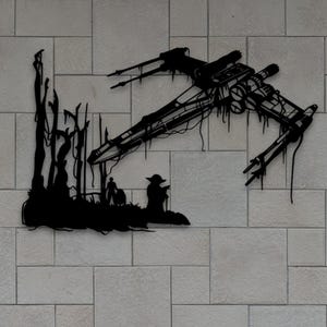 Puede incluir: Arte mural de metal negro que representa un caza estelar y una escena con figuras. La obra de arte está montada en una pared de ladrillos gris claro, con follaje verde en la parte inferior. La imagen incluye abreviaturas de tipo de archivo: AI, SVG, DXF, PDF, DWG, CDR y JPG.