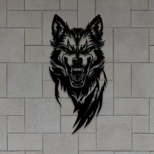 Puede incluir: Arte mural de cabeza de lobo de metal negro. El lobo se representa con la boca abierta, mostrando los dientes y una expresión feroz. La obra de arte está montada en una pared de ladrillo gris claro, con follaje verde en la parte inferior. La imagen también incluye abreviaturas de tipos de archivo.