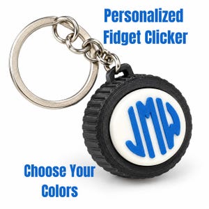 May include: A round black fidget clicker keychain with a white center button featuring the blue monogram letters JMW. The device includes a silver metal split ring attached by a short chain. Text on the image reads Personalized Fidget Clicker and Choose Your Colors.