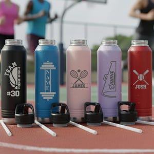 May include: A collection of personalized water bottles in various colors, including black, blue, pink, purple, and red. Each bottle features a different design, such as a basketball, weightlifting, tennis rackets, a megaphone, and baseball bats, along with custom names.