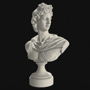 Könnte beinhalten: Weiße Marmorbüste eines Mannes mit lockigem Haar, der ein drapiertes Tuch trägt, auf einem Sockel.