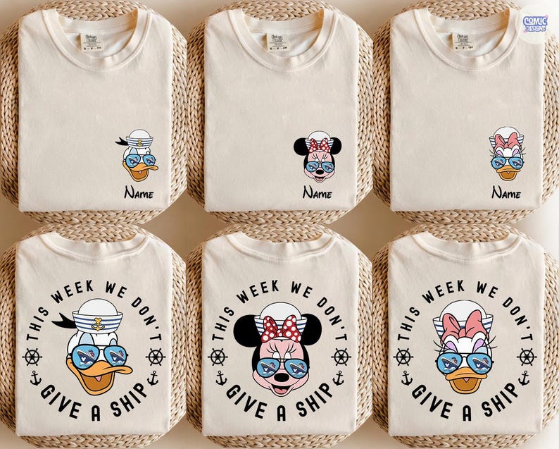 May include: Six cream-colored t-shirts, each folded and arranged on a woven mat. The shirts feature cartoon characters like Donald Duck, Minnie Mouse, and Daisy Duck, wearing sunglasses. Some shirts have the text "This Week We Don't Give a Ship."