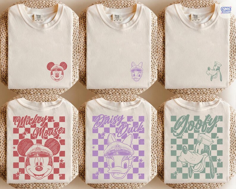 May include: Cream-coloured t-shirts with Mickey Mouse, Daisy Duck, and Goofy designs. The shirts feature graphics of Mickey Mouse in a red checkered pattern, Daisy Duck in a purple checkered pattern, and Goofy in a green checkered pattern.