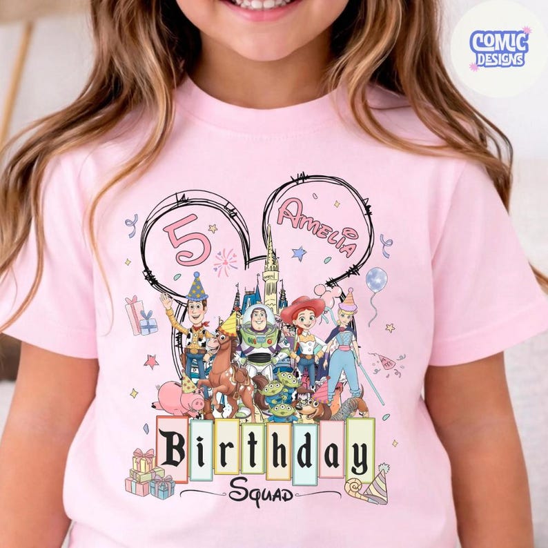 May include: Pink t-shirt featuring a colorful graphic of Toy Story characters, the number 5, and the name Amelia. The words "Birthday Squad" are also displayed. The design is set within a Mickey Mouse ear outline.
