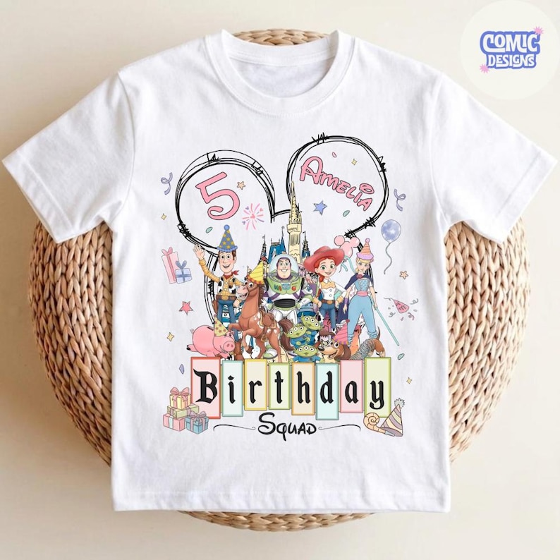 May include: White t-shirt featuring a colorful graphic of Disney characters, the number 5, and the name "Amelia" in a Mickey Mouse ear design. The words "Birthday Squad" are also displayed. The shirt is decorated with party-themed elements.