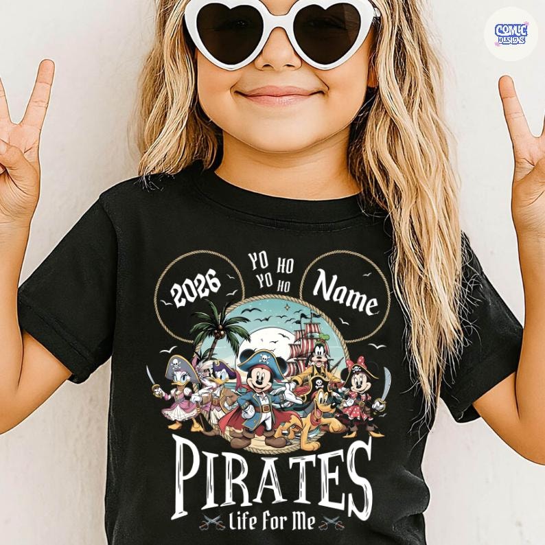 May include: Black t-shirt featuring a colorful pirate-themed graphic. The design includes cartoon characters, a pirate ship, and the text "PIRATES life for me". Additional text includes "2026", "Yo Ho Yo Ho", and a space for a name.