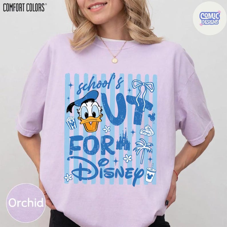 May include: Orchid-colored t-shirt with a graphic that says "school's out for Disney" in blue. The design includes Donald Duck, popcorn, a castle, and other Disney-themed elements. The shirt is from Comfort Colors.