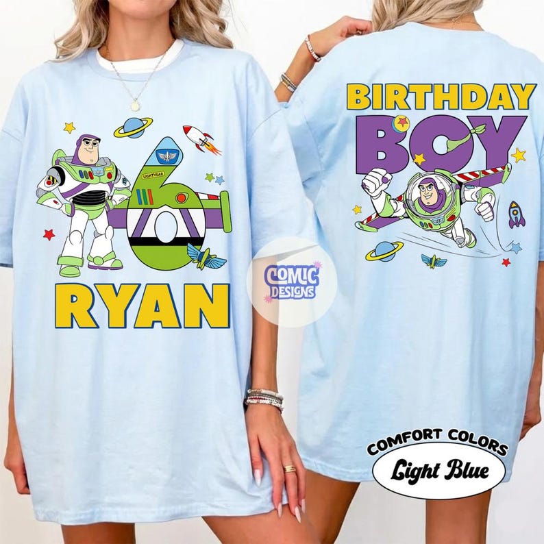 Puede incluir: Camisetas azul claro con dise&ntilde;os de Buzz Lightyear. Una camiseta tiene "RYAN" y un dise&ntilde;o con el n&uacute;mero 6. La otra dice "BIRTHDAY BOY". Ambas camisetas tienen ilustraciones tem&aacute;ticas espaciales y las palabras "COMFORT COLORS Light Blue".