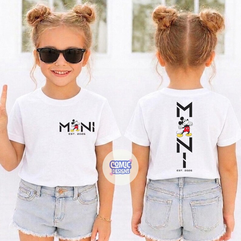May include: White t-shirts with a Mickey Mouse design. The front of the shirt says "MINI" with Mickey Mouse and "EST. 2026". The back of the shirt has a vertical design with Mickey Mouse and "EST. 2026". The shirts are worn by a young girl.