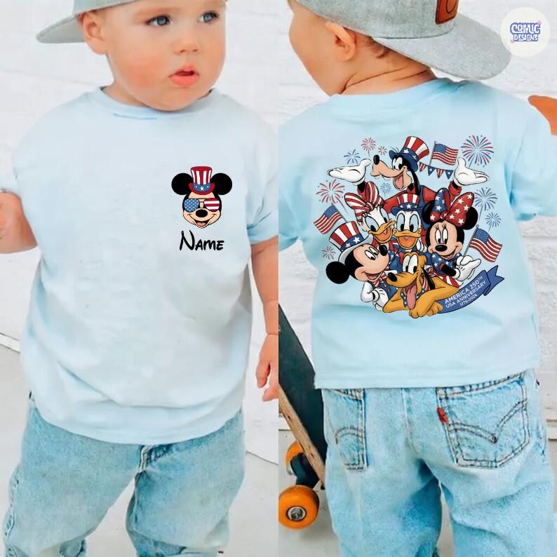 May include: Light blue t-shirt featuring Mickey Mouse in patriotic attire with the text "Name". The back of the shirt displays Mickey, Minnie, Donald, Goofy, and Pluto with American flags and fireworks. The shirt is part of the "America 250th USA Anniversary" collection.