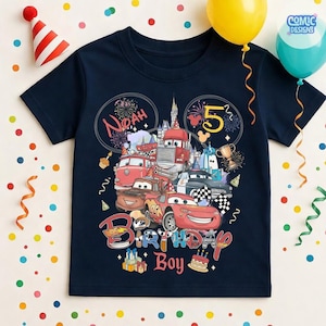 以下が含まれることがあります： ネイビーブルーの半袖Tシャツ。漫画の車、花火、お城のカラフルなグラフィックが特徴です。シャツには「Noah」という名前、「5」という数字、「Birthday Boy」という言葉が含まれています。背景には風船と紙吹雪があります。