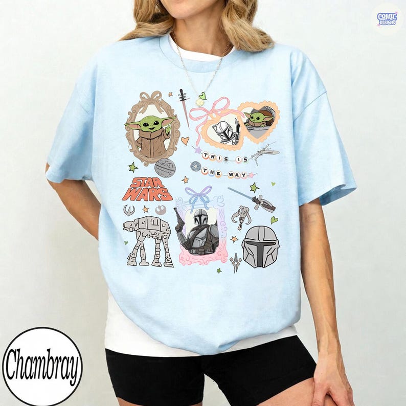 Puede incluir: Camiseta azul claro con personajes y frases de Star Wars. El dise&ntilde;o incluye ilustraciones de Grogu, el Mandaloriano y el texto "This is the Way". La camiseta tiene cuello redondo y mangas cortas.
