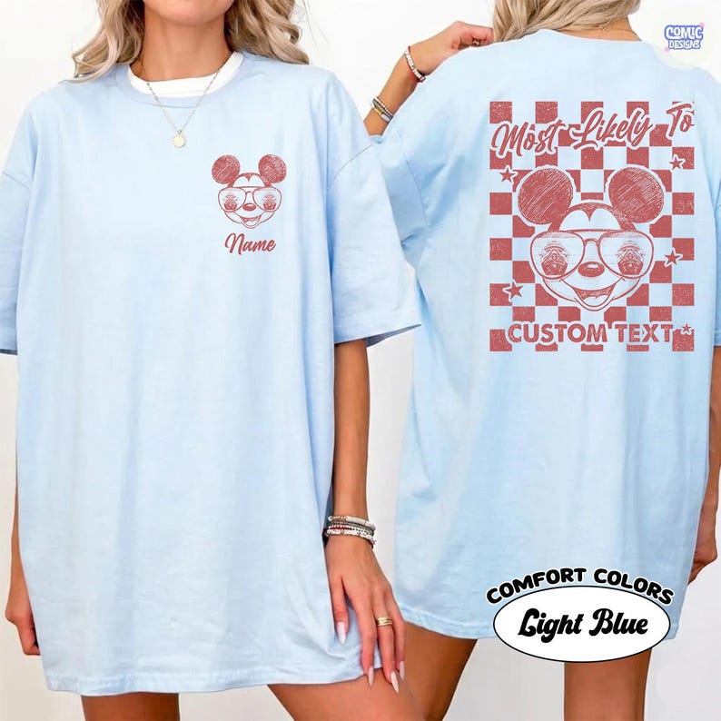 May include: Light blue t-shirt with a red Mickey Mouse graphic on the front and back. The front features a Mickey Mouse head with the word "Name" below. The back has a checkered background with the words "Most Likely To" and "Custom Text".