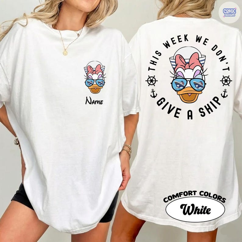 May include: White t-shirt featuring a cartoon duck wearing sunglasses and a bow. The front of the shirt has the word "Name" below the duck. The back of the shirt has the phrase "This week we don't give a ship" in a circular design.