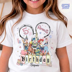 May include: White t-shirt featuring a colorful graphic of Disney's Toy Story characters. The design includes the number 5, the name Amelia, and the words "Birthday Squad". The shirt has a crew neck and short sleeves.