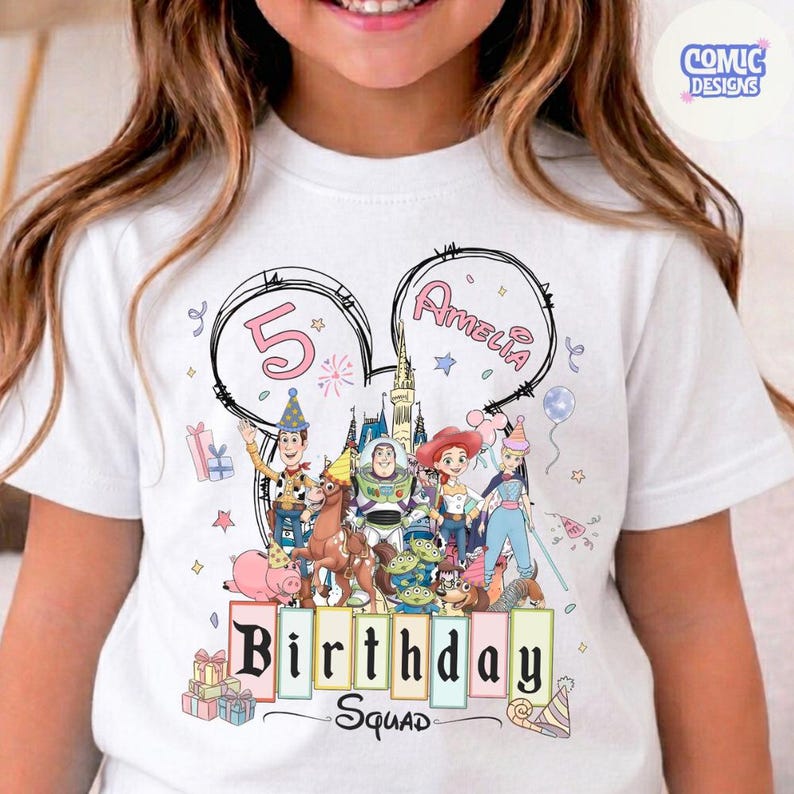 May include: White t-shirt featuring a colorful graphic of Disney's Toy Story characters. The design includes the number 5, the name Amelia, and the words "Birthday Squad". The shirt has a crew neck and short sleeves.