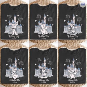 May include: Six black t-shirts featuring Disney characters and the text "Disney Trip 2026". Each shirt displays a different character in front of a castle with fireworks. Characters include Buzz Lightyear, Winnie the Pooh, Minnie Mouse, Olaf, Mickey Mouse, and Stitch.