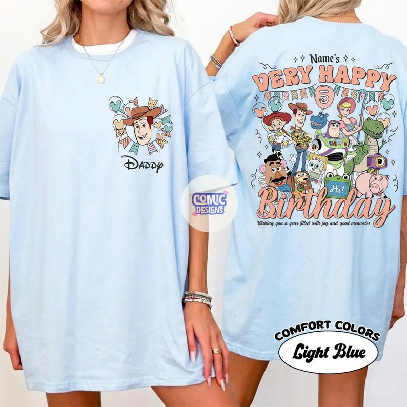 May include: Light blue t-shirt featuring a cartoon graphic of Woody from Toy Story with the word "Daddy" below. The back of the shirt has a "Very Happy Birthday" design with various Toy Story characters and the number 5.