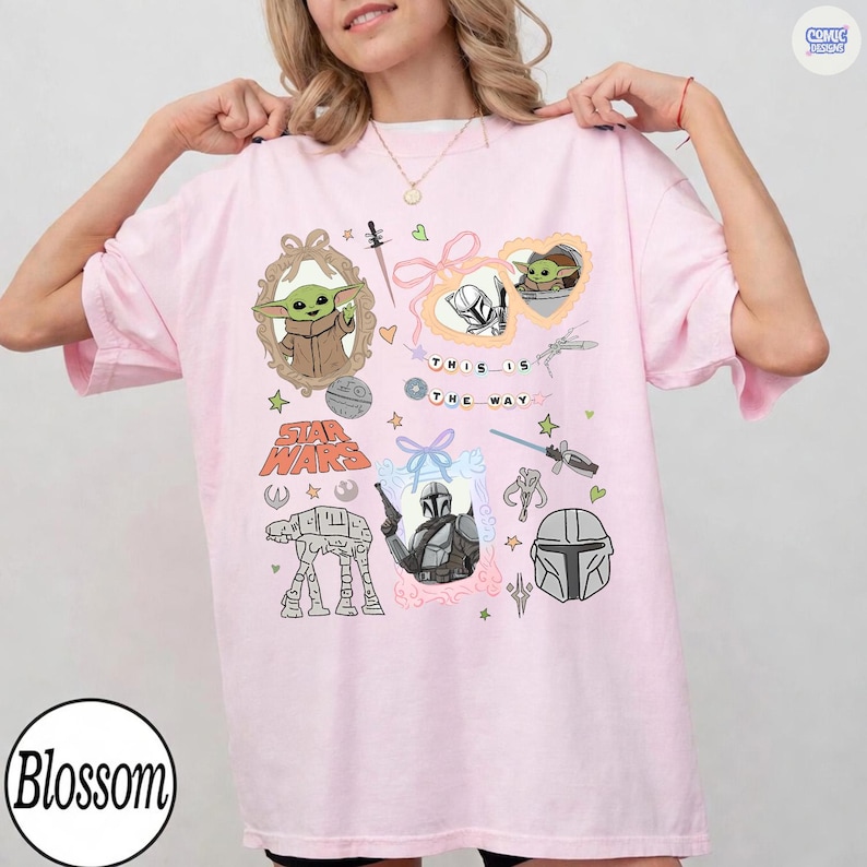 Puede incluir: Camiseta rosa claro con gr&aacute;ficos de Star Wars, incluyendo a Grogu y el Mandaloriano. La camiseta presenta el texto "THIS IS THE WAY" y "STAR WARS" en un dise&ntilde;o l&uacute;dico.