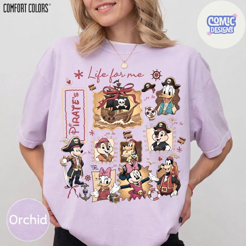 May include: Orchid-colored t-shirt with a pirate-themed graphic featuring cartoon characters and a pirate ship. The design includes the text "Life for me" and "Pirate's". The shirt is from Comfort Colors and Comic Designs.