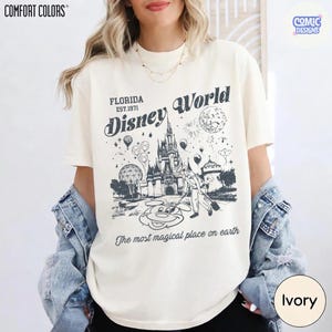 K&ouml;nnte beinhalten: Elfenbeinfarbenes T-Shirt mit einer schwarz-wei&szlig;en Grafik des Disney World Schlosses, Mickey Mouse und dem Text "Florida Disney World" und "The most magical place on earth."
