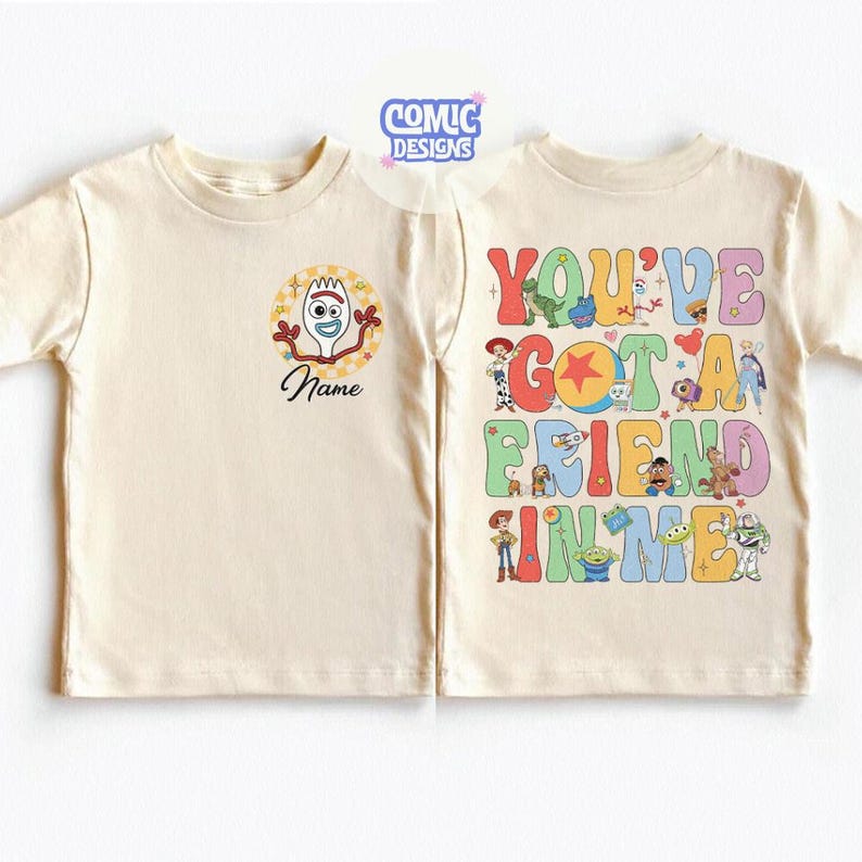 Op de afbeelding: Een cr&egrave;mekleurig t-shirt met een kleine afbeelding van Forky op de linkerborst en het woord Name eronder. De achterkant toont een grote, kleurrijke afbeelding met de tekst YOU'VE GOT A FRIEND IN ME en diverse Toy Story personages.