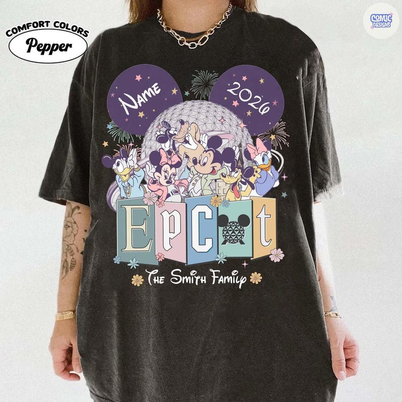 May include: Dark gray t-shirt featuring a colorful graphic of Disney characters in front of a geodesic sphere. The word "EPCOT" is displayed in pastel colors, with "The Smith Family" below. The shirt includes the text "Name" and "2026" in Mickey Mouse ear shapes.