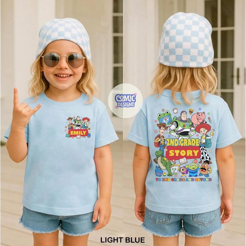 May include: A light blue t-shirt featuring a small Toy Story character graphic on the front with the name EMILY and a large, detailed Toy Story character graphic on the back with the text 2ND GRADE STORY TO 2ND GRADE AND BEYOND.