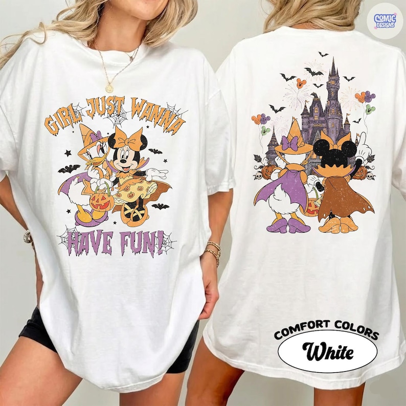 May include: A white t-shirt featuring a front graphic of Daisy Duck and Minnie Mouse in Halloween costumes with the text "GIRL JUST WANNA HAVE FUN!" and a back graphic of the two characters facing a castle with bats, pumpkins, and balloons.