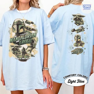 Puede incluir: Camiseta azul claro con un dise&ntilde;o de Star Wars con The Mandalorian y Grogu. El gr&aacute;fico frontal incluye el casco del Mandaloriano y Grogu, con el texto "THIS IS THE WAY". La parte posterior tiene im&aacute;genes adicionales de Star Wars.