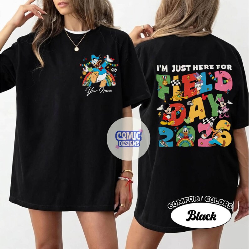 K&ouml;nnte beinhalten: Schwarzes T-Shirt mit einer farbenfrohen Grafik mit Donald Duck, Mickey Mouse und Minnie Mouse. Auf der Vorderseite des Shirts steht "Your Name" und auf der R&uuml;ckseite "I'm Just Here For Field Day 2023".