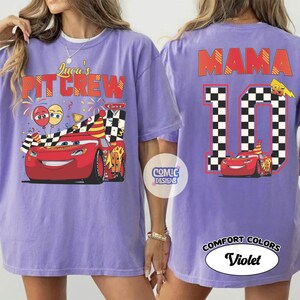 May include: A violet Comfort Colors t-shirt featuring a graphic of the Cars character Lightning McQueen. The front reads "Luca's Pit Crew" and the back displays "Mama 10". The design includes checkered flags and birthday elements.
