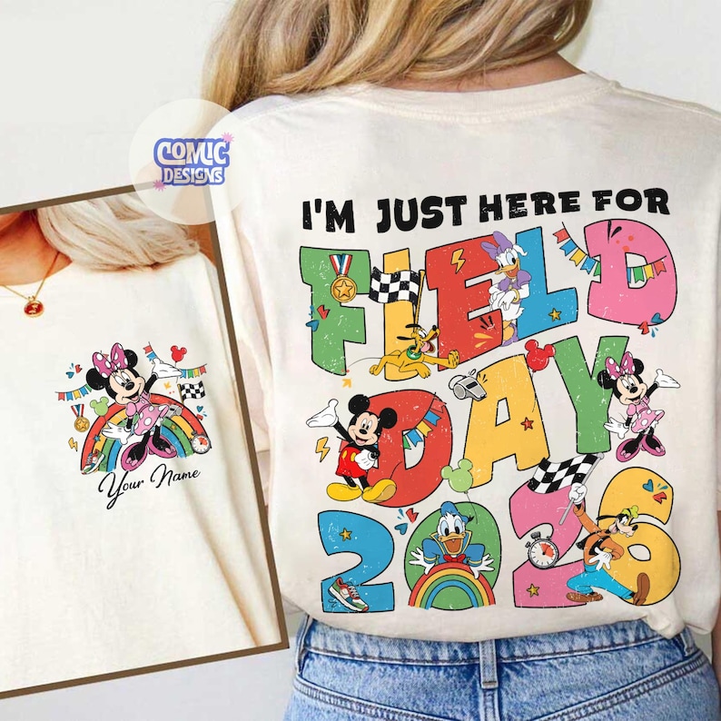 K&ouml;nnte beinhalten: Cremefarbenes T-Shirt mit einer bunten Grafik mit Micky Maus, Minnie Maus, Donald Duck und Goofy. Der Text "I'm Just Here For Field Day 2023" ist auf der R&uuml;ckseite aufgedruckt. Ein kleineres Bild von Minnie Maus befindet sich auf der Vorderseite.