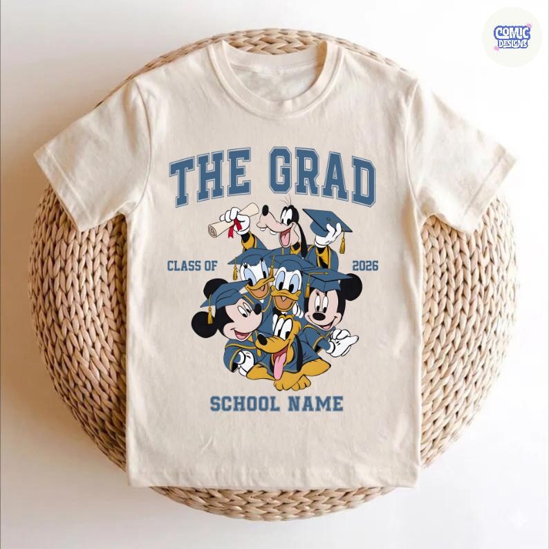 Puede incluir: Camiseta color crema con un dise&ntilde;o de graduaci&oacute;n con personajes de Disney. El texto "THE GRAD" est&aacute; encima de los personajes, con "CLASS OF 2026" y "SCHOOL NAME" debajo. Los personajes incluyen Mickey Mouse, Pato Donald, Goofy y otros.