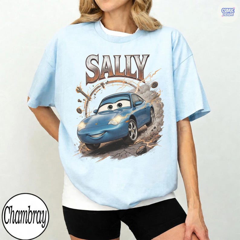 Pode incluir: Camiseta azul clara com uma imagem de desenho animado de Sally Carrera do filme Carros. O nome "SALLY" &eacute; impresso acima do carro em marrom e branco. A camiseta tem gola redonda e mangas curtas.