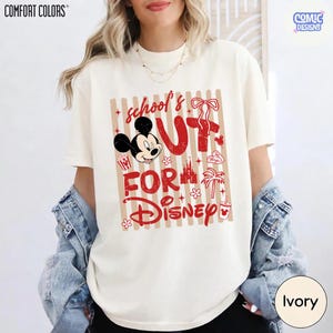May include: Ivory-colored Comfort Colors t-shirt with a red and tan graphic. The graphic says "School's Out For Disney" with Mickey Mouse, popcorn, a castle, and a palm tree. The shirt has a crew neck and short sleeves.