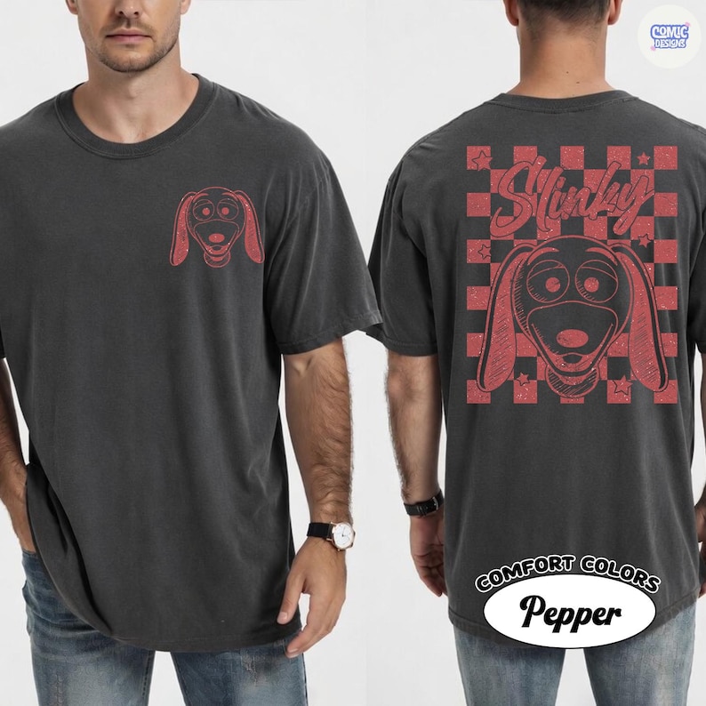Puede incluir: Camiseta gris oscuro con un gr&aacute;fico rojo de Slinky Dog en la parte delantera y trasera. La parte trasera presenta un patr&oacute;n de cuadros y la palabra "Slinky". La camiseta est&aacute; hecha de tela Comfort Colors Pepper.