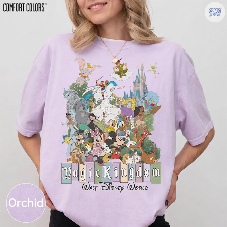 Puede incluir: Camiseta color orqu&iacute;dea con un gr&aacute;fico de varios personajes de Disney, incluyendo Mickey Mouse y Peter Pan, y el castillo de Cenicienta. El texto "Magic Kingdom Walt Disney World" est&aacute; impreso debajo. La camiseta es de Comfort Colors.