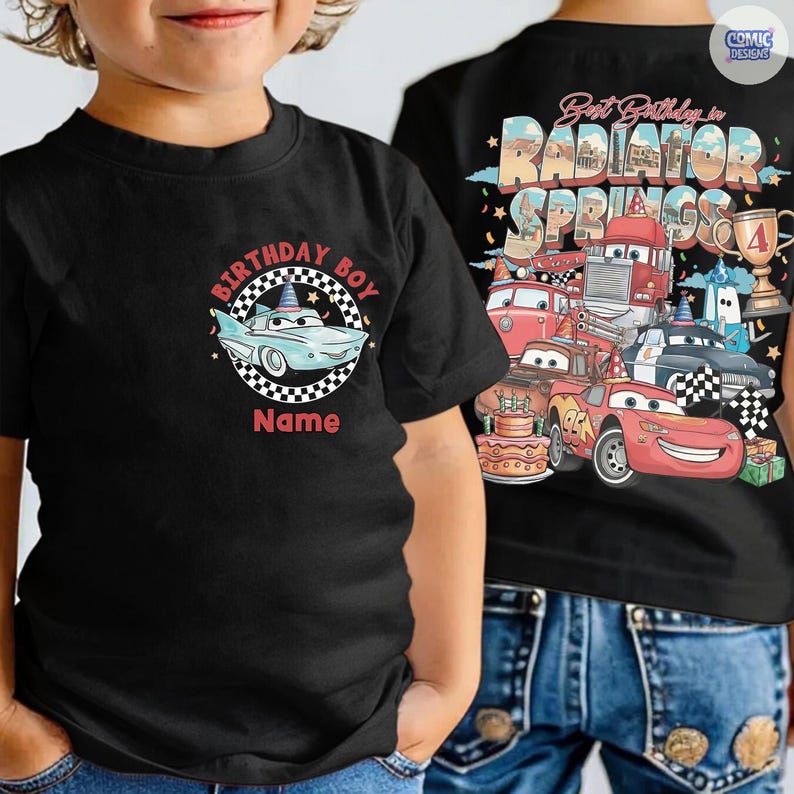 May include: Black short-sleeved t-shirt featuring a cartoon car design with the text "BIRTHDAY BOY" and "Name" in red. The back of the shirt displays a colorful graphic of cars and the text "Best Birthday in Radiator Springs".