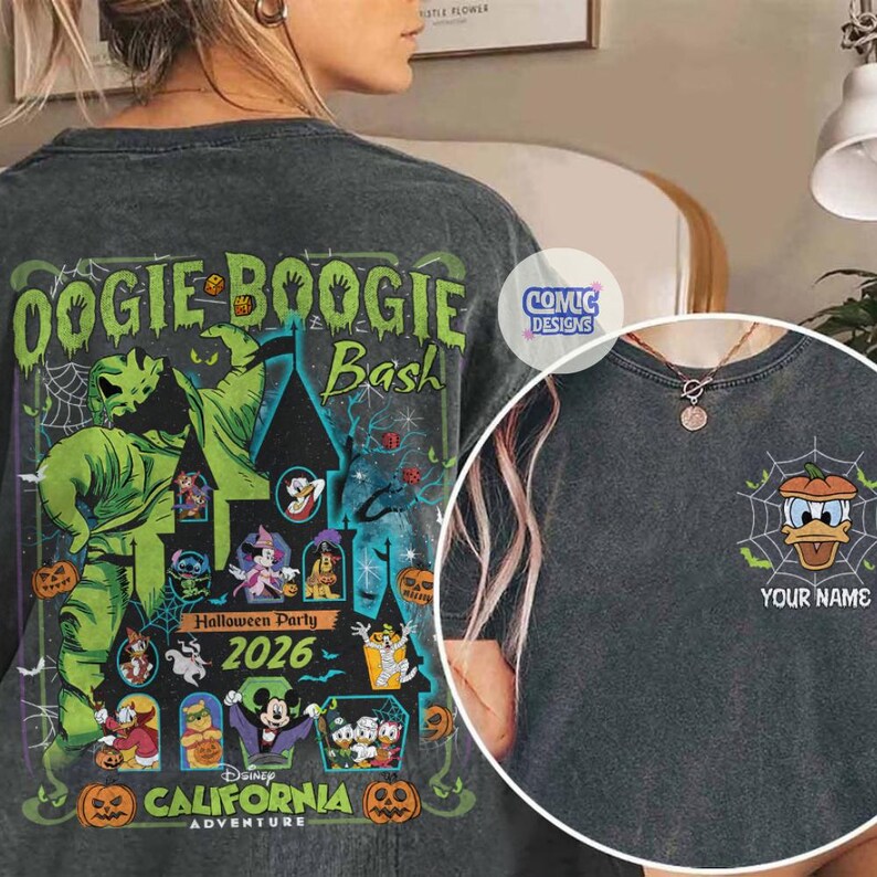 May include: Dark gray t-shirt featuring a Halloween-themed design. The back of the shirt displays the text "Oogie Boogie Bash" with a graphic of a green character and other Disney characters. The front has a Donald Duck pumpkin design with the text "YOUR NAME".