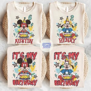 Puede incluir: Cuatro camisetas color crema con dise&ntilde;os de cumplea&ntilde;os. Dos camisetas presentan a Mickey Mouse con el nombre "Austin" y el n&uacute;mero "6". Las otras dos camisetas muestran a Goofy con el nombre "Henry" y el n&uacute;mero "2". Todas las camisetas tienen el texto "It's My Birthday".