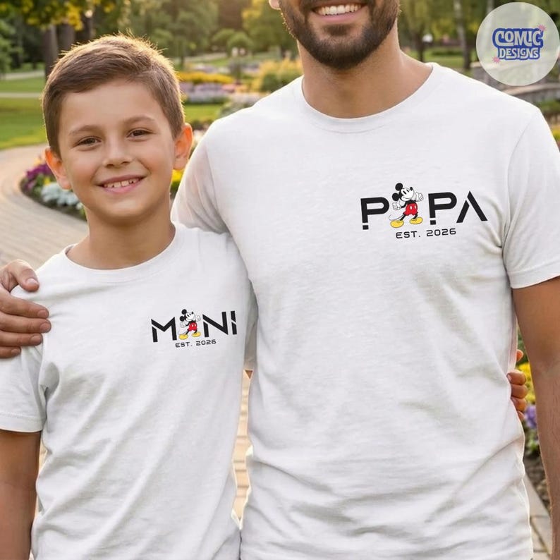 May include: Two white t-shirts with matching designs. One shirt says "PAPA" with a Mickey Mouse graphic and "EST. 2026". The other shirt says "MINI" with a Mickey Mouse graphic and "EST. 2026".