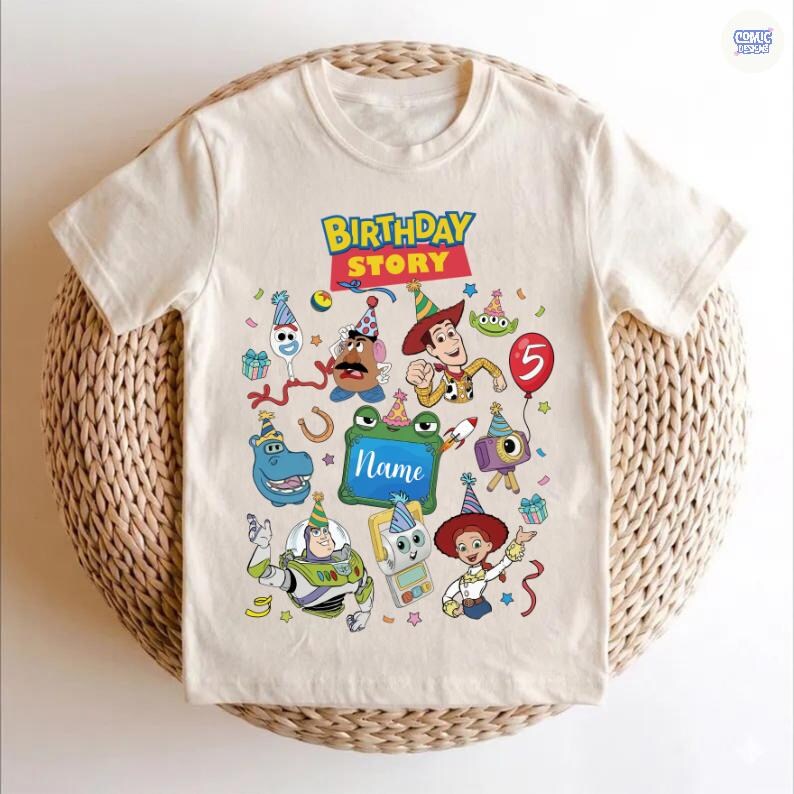 May include: A cream-colored short-sleeve t-shirt featuring a colorful graphic print with the text Birthday Story. The design includes various cartoon characters wearing party hats, confetti, a red balloon with the number 5, and a green frame.
