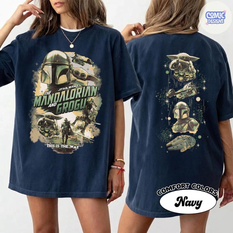 Puede incluir: Camiseta azul marino con gr&aacute;ficos de The Mandalorian y Grogu. La parte delantera muestra el casco del Mandaloriano y Grogu, con el texto "The Mandalorian and Grogu" y "This is the Way". La parte trasera muestra ilustraciones de personajes y naves.