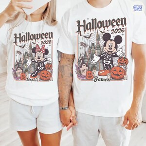 May include: White t-shirts with a Halloween 2026 design. The design features Mickey and Minnie Mouse dressed as skeletons, pumpkins, a castle, and the names "Sophia" and "James".